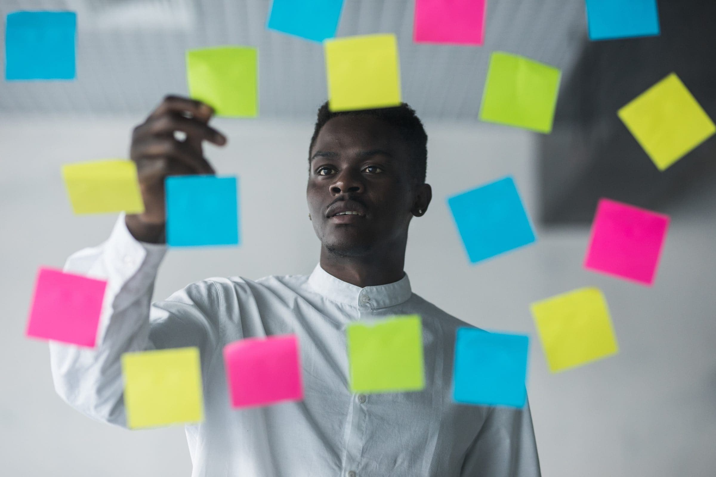 Strategist planning with notes on a glass wall